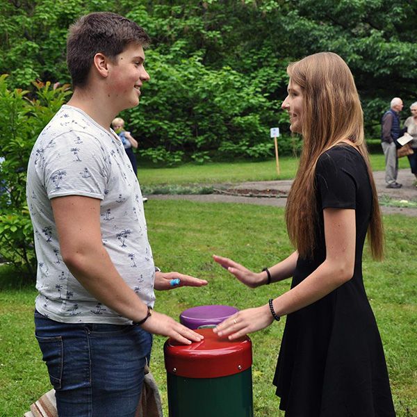 Lady and Man Playing Outdoor Conga Drums in a Playground