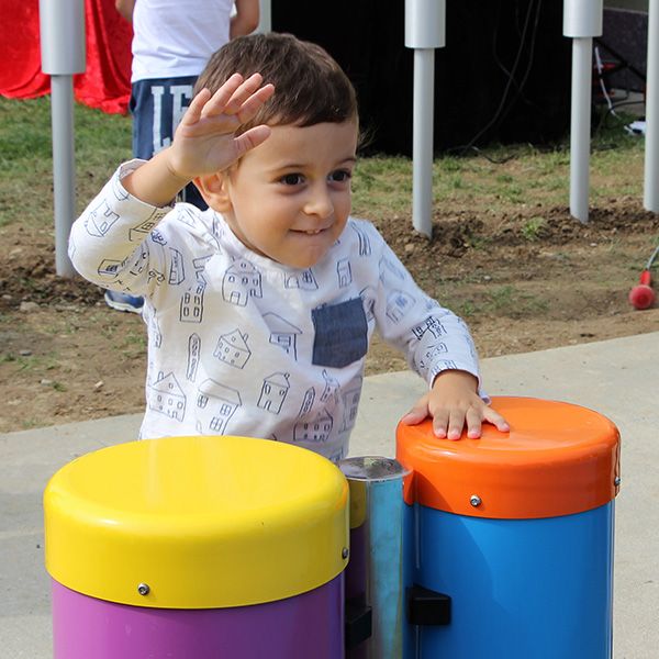 Young Boy Smiling Playing Outdoor Conga Drums