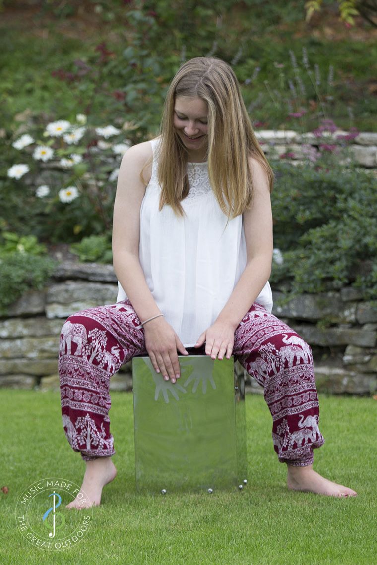 Teenage Girl Playing Stainless Steel Cajon Drum in Garden