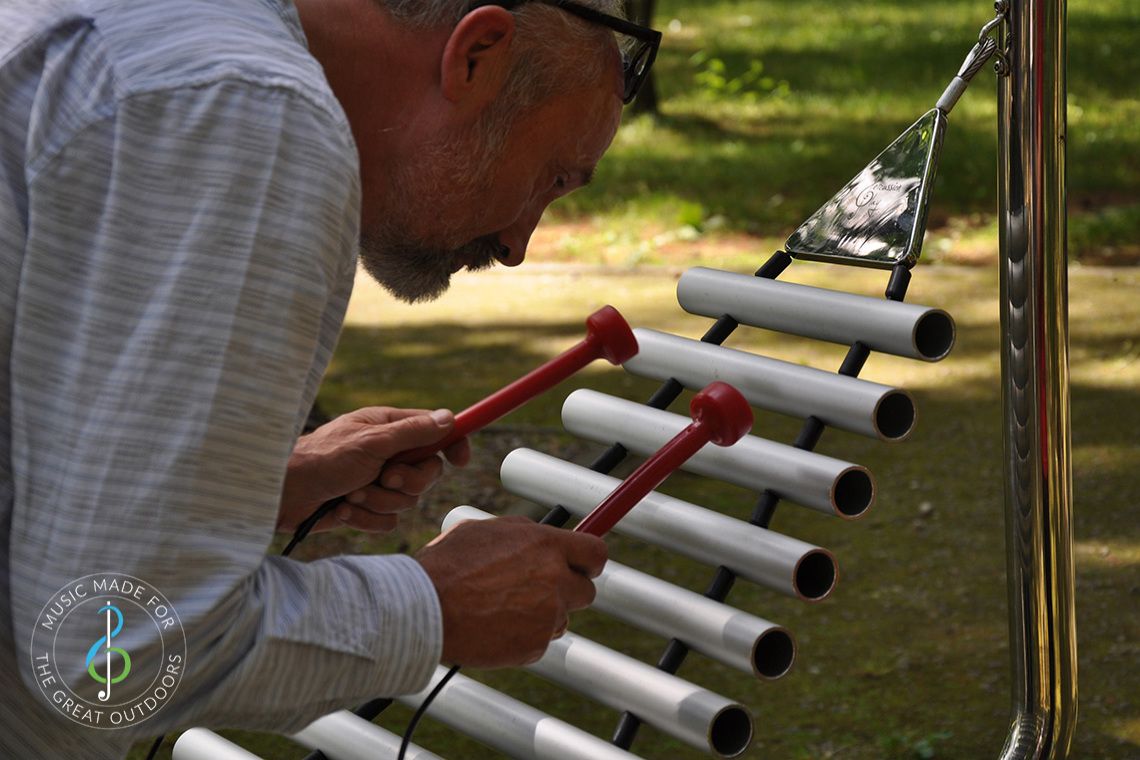 close up of elder man playing a xylophone in the park