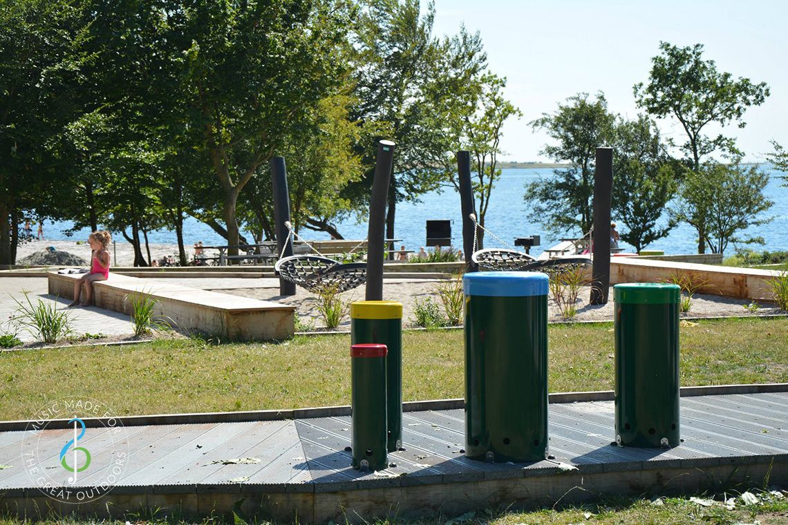 colourful outdoor drums in playground with sea in the background