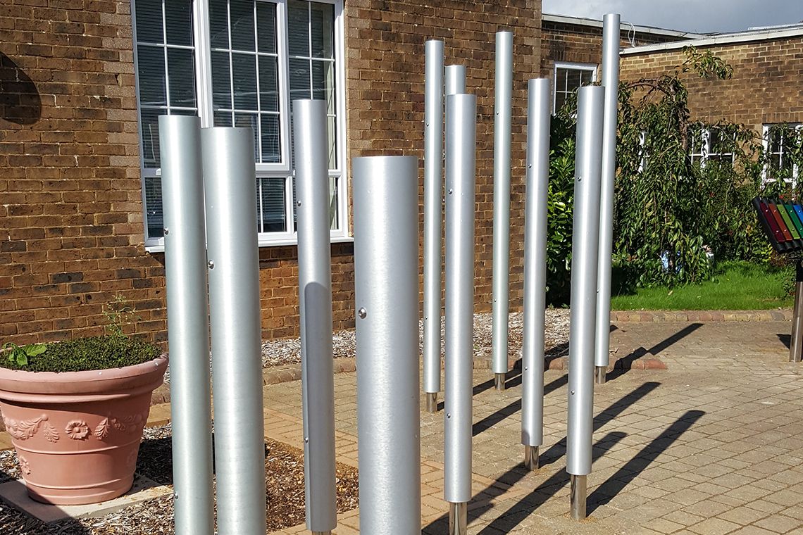 Tall silver chimes installed in a playground