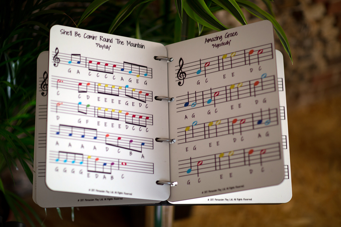 A large music book to accompany an outdoor musical instruments using a rainbow scale